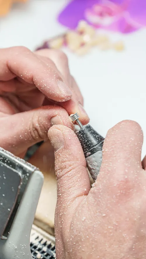 Zahntechniker bearbeitet eine Arbeit von Hand